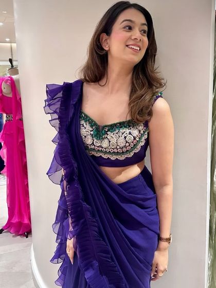 A smiling guest in a beautiful purple ruffled sari from Ridhi Mehra's collection. Seeing guests enjoy themselves and connect with the designs is the ultimate measure of a successful event.