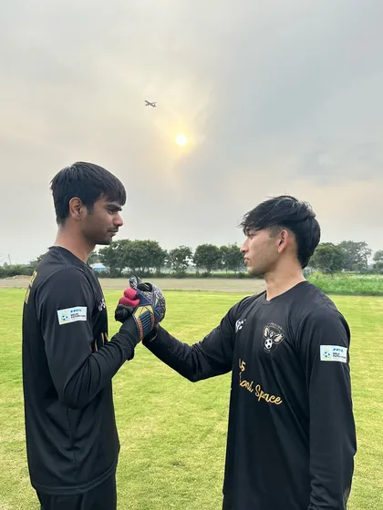 Brothers in goal. Our two goalkeepers share a handshake of respect and solidarity under the evening sun.