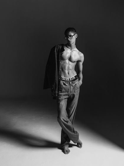 Another full-length black and white shot, this time with the jacket slung over the shoulder. This pose adds a sense of movement and casual elegance to the campaign.