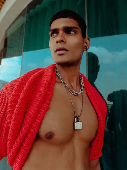 An outdoor shot for an Amama Jewels campaign. The image uses natural light and a reflective background to create a modern, vibrant feel that highlights the men's jewelry collection.