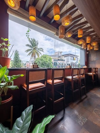 We designed this high-top seating area to take full advantage of the large window and the view. The natural light and hanging bamboo lights create a bright and airy spot for guests to enjoy a drink.