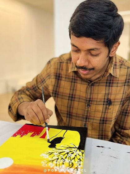 A close-up of a participant painting a silhouette on his canvas during a couples' anniversary art date.