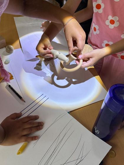 In our emergent literacy workshop, children explore light and shadow. By tracing the shadows of objects, they develop fine motor control and visual thinking, turning a science concept into a pre-writing and storytelling activity.
