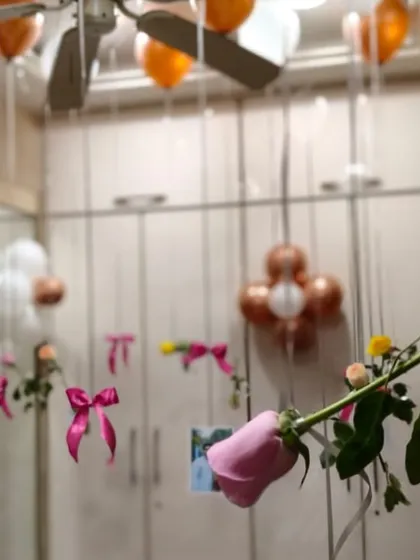 A really personal touch is to hang photos from the balloons. Here, I attached pictures and single pink roses to the ribbons of helium balloons, letting them float above the bed and around the room as a sweet surprise.