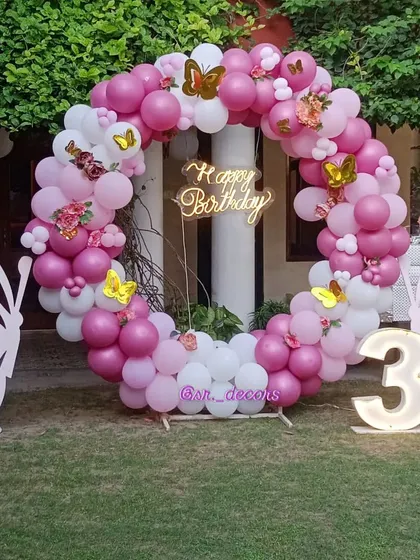 Perfect for a garden party, this butterfly theme for a third birthday features a full balloon ring in shades of pink and white, accented with beautiful butterfly cutouts and a light-up number '3'.