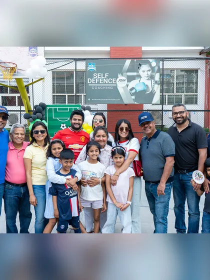A happy family group photo at the outdoor football party, capturing a beautiful memory.