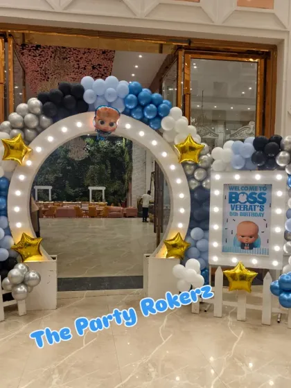 I make sure the party entrance is as grand as the party itself. For this Boss Baby theme, I created a large lighted archway with a personalized welcome sign, setting the perfect tone for a stylish event at a banquet hall.