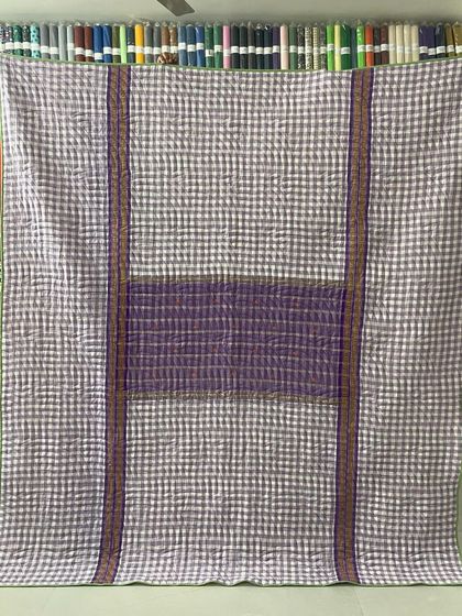 A reversible memory quilt made from a checked saree, giving it a modern, graphic look.