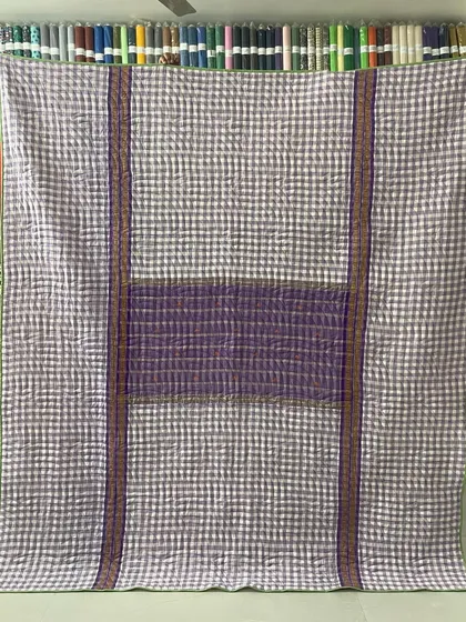 A reversible memory quilt made from a checked saree, giving it a modern, graphic look.