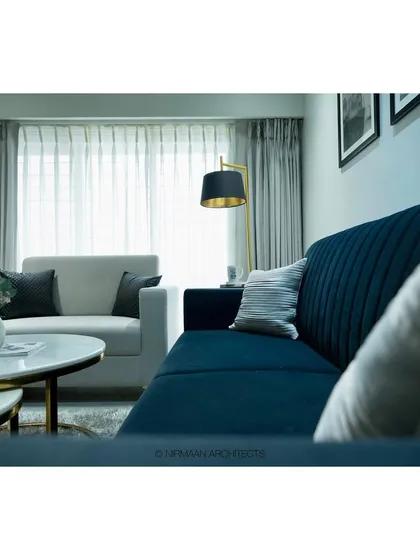 A close-up of the navy blue sofa in the Tulsi Heights living room. The choice of a rich, dark color grounds the space and adds a touch of contemporary sophistication.