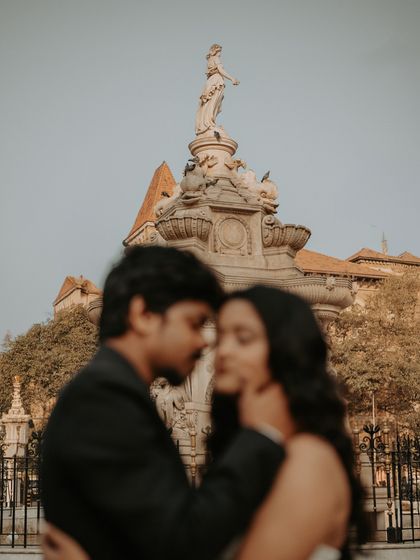 A soft-focus shot creating a dreamy, romantic mood, with the Flora Fountain monument in the background.