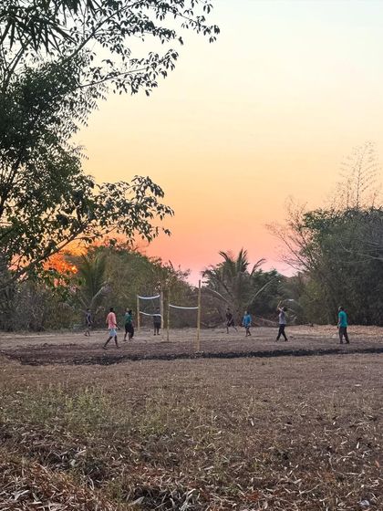 The sunset paints the sky with warmth as evening settles over the ashram. These quiet moments of reflection by the river or among the trees are a cherished part of the daily rhythm here.