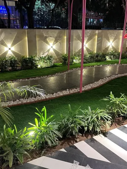 The right lighting transforms a garden at night. I used a combination of wall-mounted uplighters and subtle ground lights to create a warm, inviting atmosphere in this whimsical garden, making it perfect for evening relaxation.