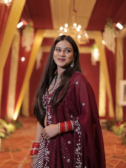 A beautiful portrait of the client in her maroon chevron lehenga, her hair flowing.
