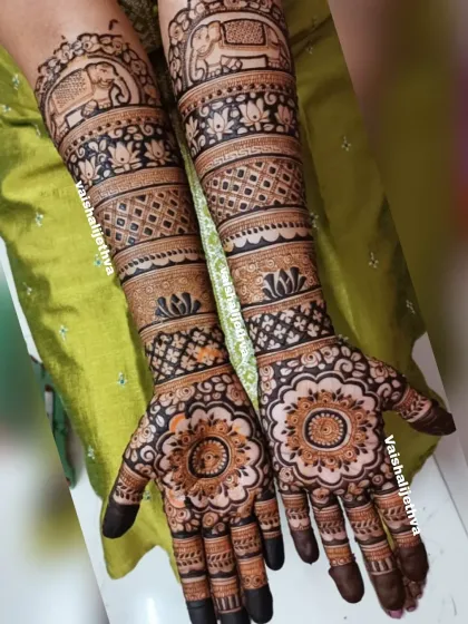 A simple yet elegant bridal mehndi. This design focuses on beautiful floral mandalas on the palms and traditional bands with elephant motifs on the arms.