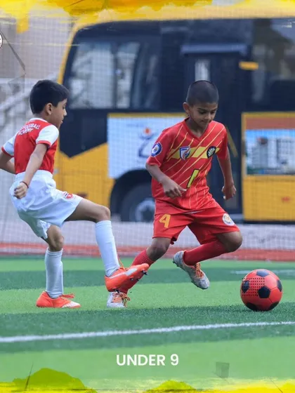 A young U9 player dribbles past an opponent during a practice match.