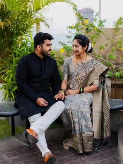 A relaxed, seated portrait of the couple. Their natural interaction and hand-holding make this a lovely, authentic photo.