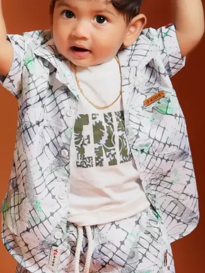 A close-up shot of a stylishly dressed baby boy, capturing his adorable outfit and expression.