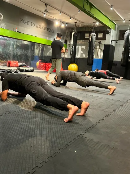 The foundation of a fighter is a rock-solid core. Here, students hold a plank, an essential exercise for building the stability and endurance required for combat.