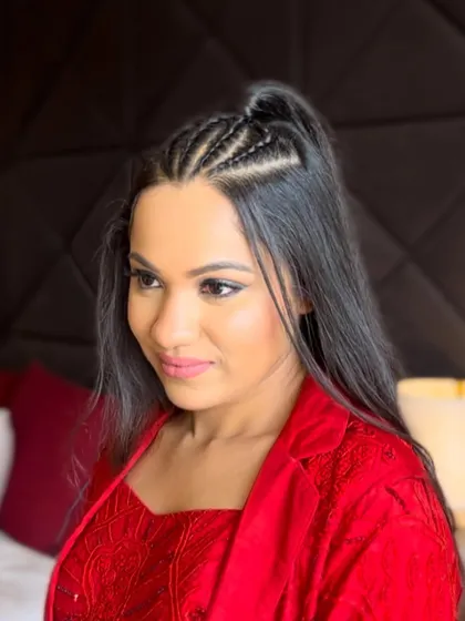 A front view of the client with her modern braided hairstyle, looking chic and ready to party.