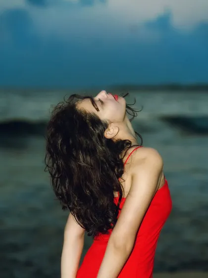 An expressive, upward-looking pose. The flash highlights the curve of her neck and the movement in her hair, creating a very artistic shot.