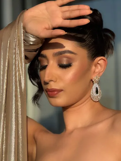 This pose highlights the flawless skin and the soft, warm tones used on the face. The makeup is designed to be photogenic, ensuring you look your best in every snapshot from your special evening.