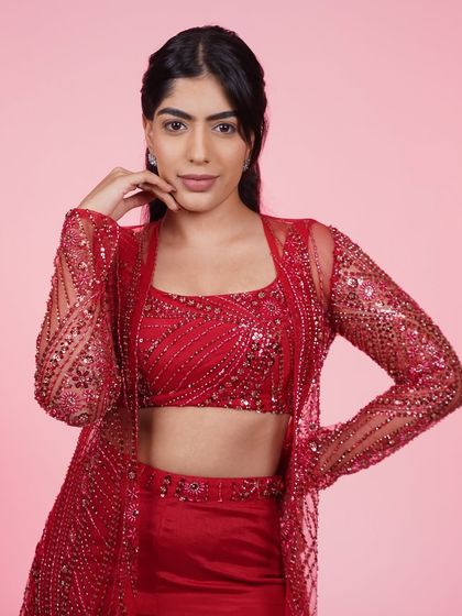 A close-up of the red three-piece Indo-Western set, showing the detailed beadwork on the crop top.
