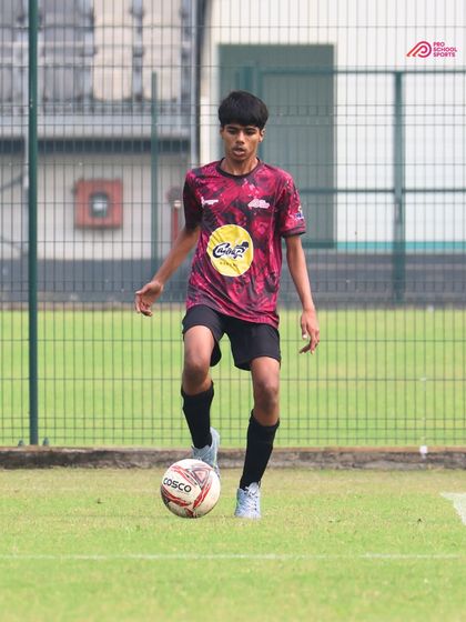 A player maintains close control of the ball, looking for an opportunity to move forward.