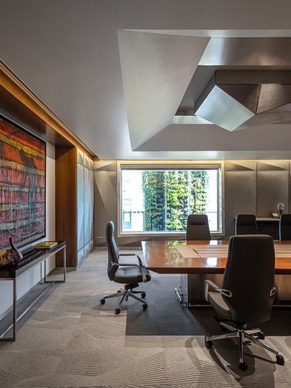 The main boardroom on the top floor of the Stainless Steel Office. The room features a dramatic, faceted ceiling element and fabric-paneled walls for improved acoustics, creating a state-of-the-art meeting facility for the company's leadership.