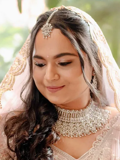 A close-up of Madhura's rosy makeup look. The soft pink tones on her eyes and cheeks give her a fresh and youthful glow.