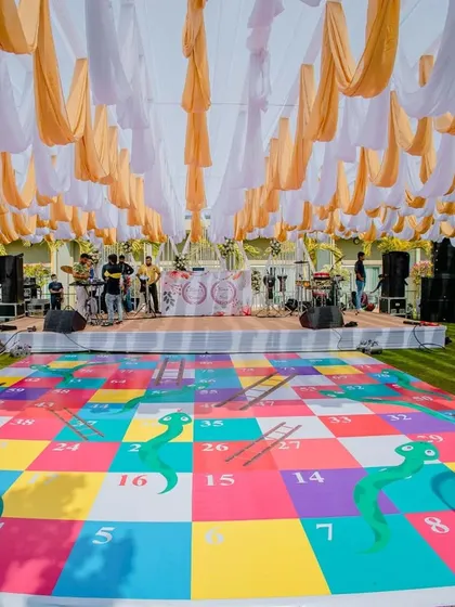 A giant snakes and ladders game board set up on the lawn for the pool party. A unique and interactive element for guests to enjoy.