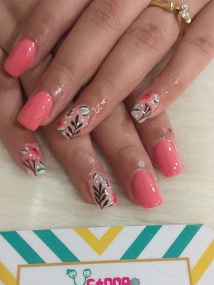 This set combines solid coral-pink nails with accent nails featuring delicate, hand-drawn floral branches. It's a beautiful way to mix solid colors with intricate artwork.