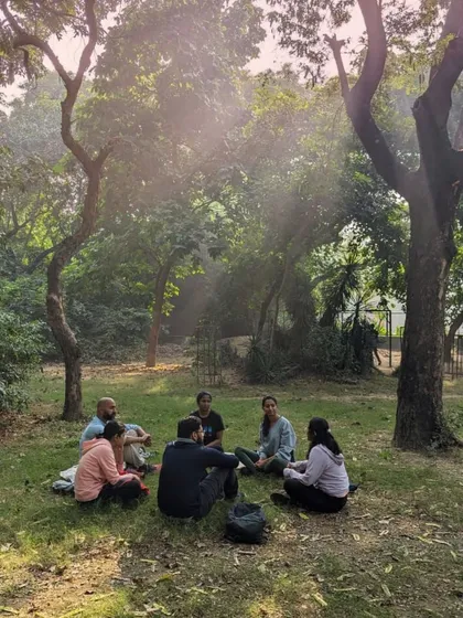 We gather in a circle under the trees during a forest therapy walk. This is a moment for shared connection, a quiet pause to absorb the calming energy of nature together.