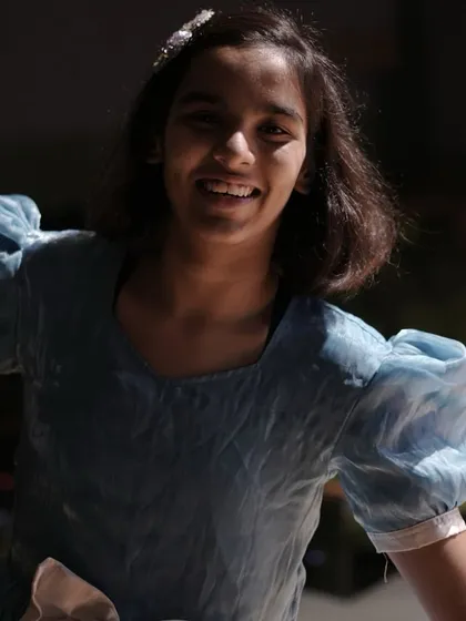 A radiant smile from our "Alice" backstage. This captures the pure joy and excitement that children feel when they are part of a creative project.