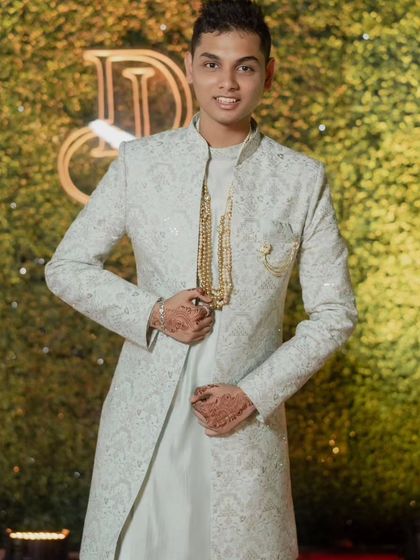 The light pista koul kurta with an embroidered open Indo-Western jacket, accessorized with a traditional necklace for a more formal, festive look.