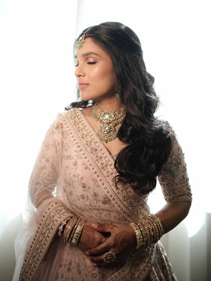 A serene moment captured. The soft waves in her hair and the gentle, glowing makeup create a look of pure elegance and calm.