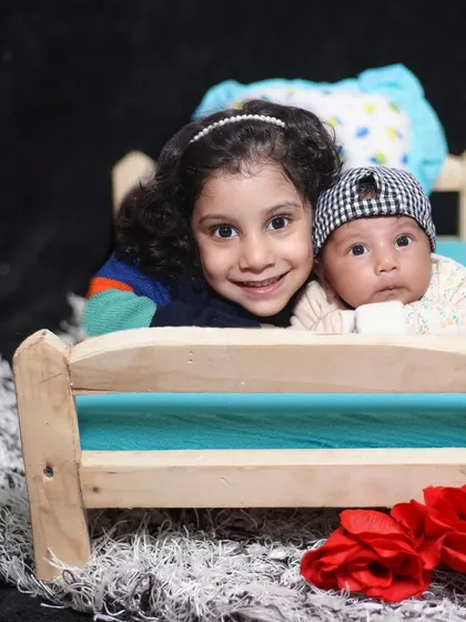A heartwarming photo of an older sister with her newborn sibling. I focus on capturing these natural, unposed moments of bonding.