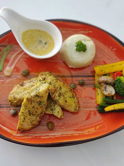 A clean, well-lit shot of our herb-crusted chicken with mashed potatoes and vegetables, highlighting the appealing colors and textures of the dish.