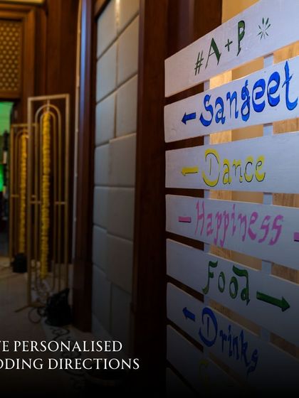 Cute and quirky wedding directions! This hand-painted sign pointed guests towards all the important things: Sangeet, Dance, Happiness, Food, and Drinks. It's a fun way to guide guests and add personality.