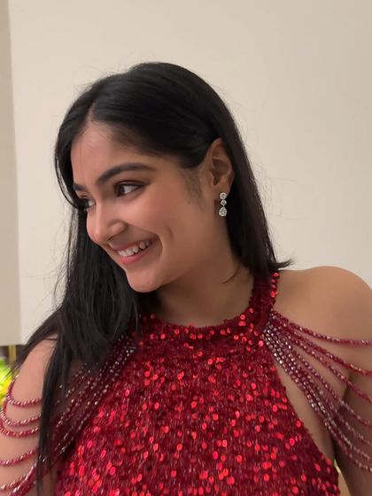 A close-up of the cocktail look. Simple diamond drop earrings were all that was needed, letting the sparkling red gown and its intricate shoulder beading be the main focus.