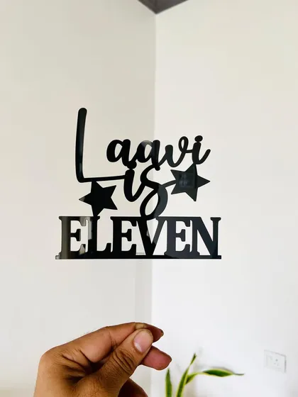 A clear, straight-on shot of the "Laavi is Eleven" topper, emphasizing its modern font and clean design.