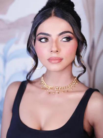 This angle shows the beautiful dimension in the eye makeup and the soft, face-framing hairstyle, creating a romantic and modern party look.