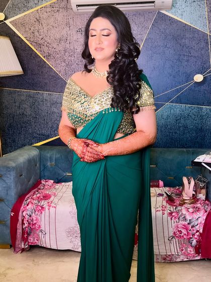 Glam with grace. This cocktail bride owned the spotlight in her emerald and gold saree, with a dewy base, glossy nude lips, and luxurious waves.