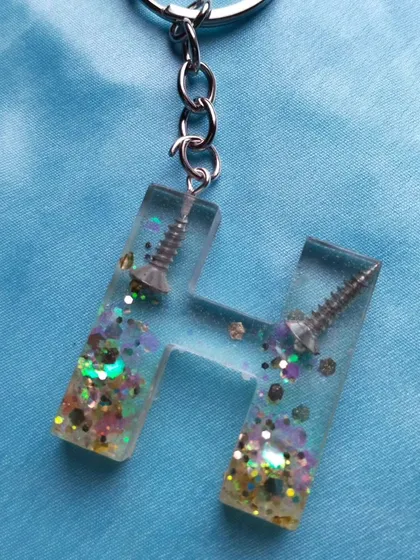 A fun and quirky keychain I made for a dad. It's a letter 'H' with actual screws and glitter embedded inside. I love getting creative with custom orders.