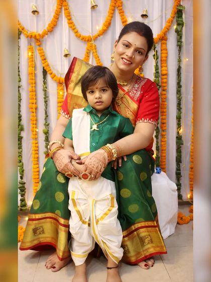 A mother and son in beautiful traditional South Indian attire pose for a formal portrait.