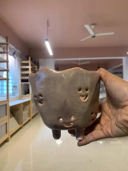 A quirky pot with smiley faces carved into it, made by one of our youngest students. It’s pure joy in ceramic form.