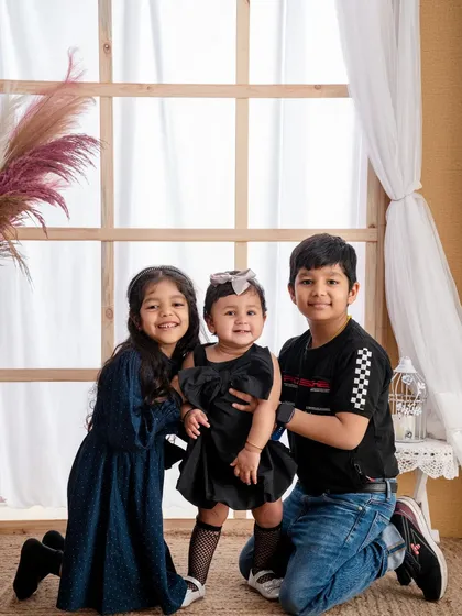 A brother and two sisters pose together, a wonderful portrait showcasing the unique bond between siblings.
