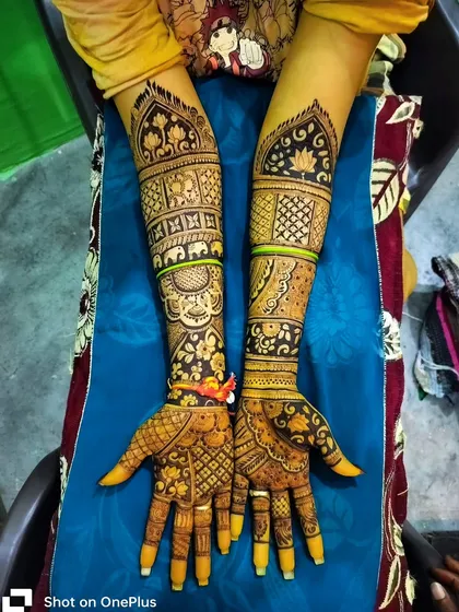 This full-arm design features bands of elephants and floral motifs. The use of bold lines and dark-filled patterns makes this a striking and traditional choice for any celebration.