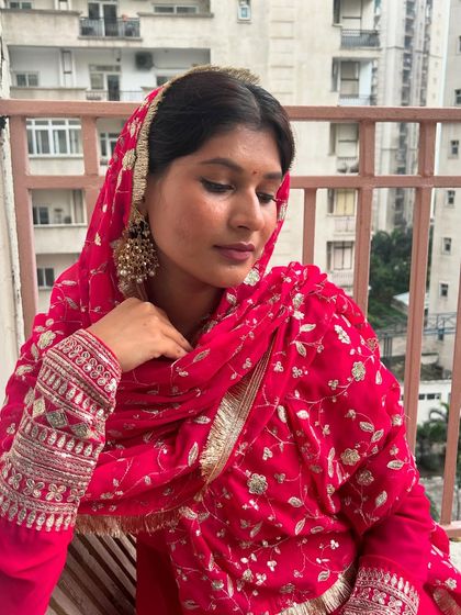 A festive look in a vibrant pink suit. The heavily embroidered dupatta and sleeves add a touch of grandeur, while the large chandbali earrings complete the traditional ensemble.