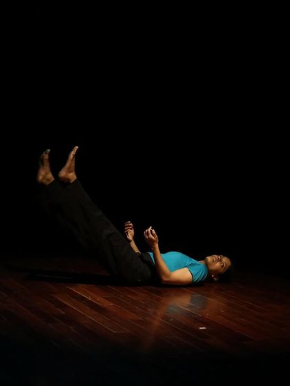 A dancer lies on the floor during a tech run.